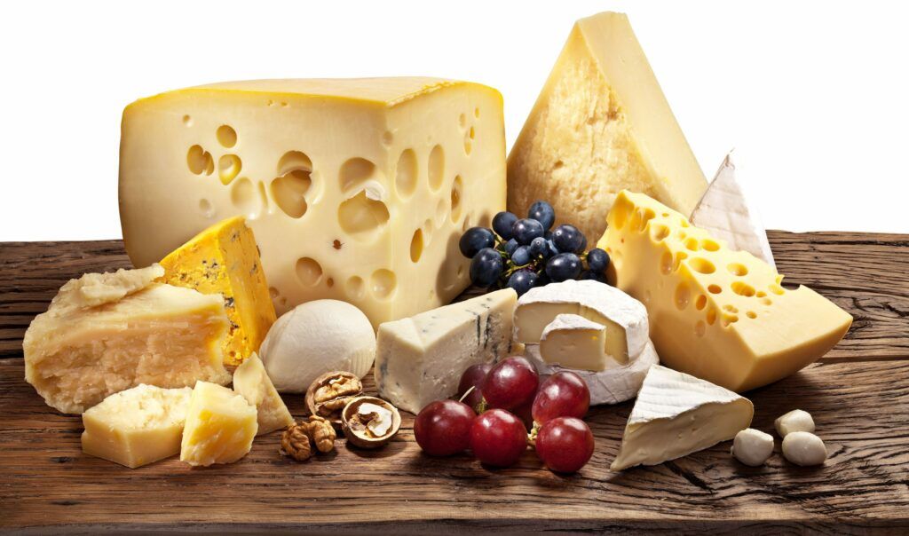 Different types of cheese over old wooden table.