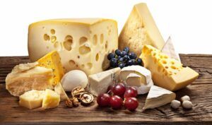 Different types of cheese over old wooden table.